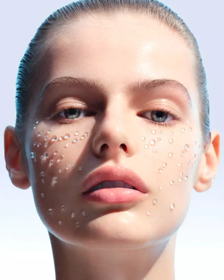 Close-up of a woman’s face with visible water droplets on the skin, illustrating hydration.