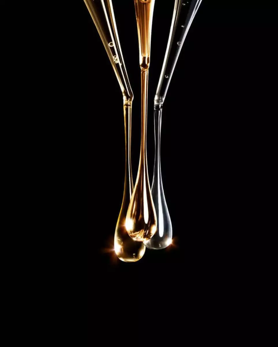 Close-up of liquid droplets falling from glass pipettes.