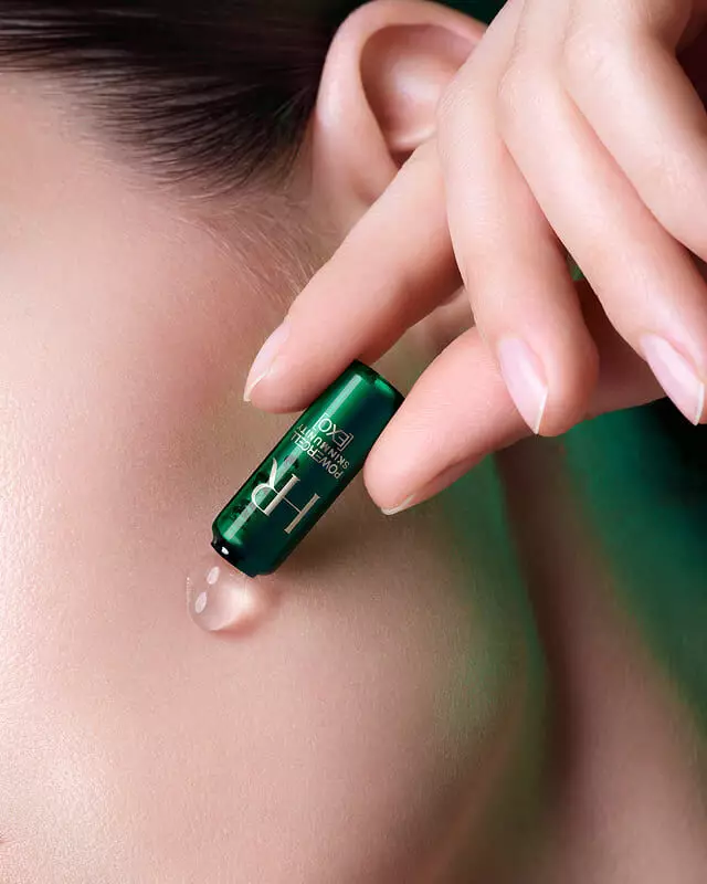 Clear serum droplet applied to cheek directly from the green ampoule.
