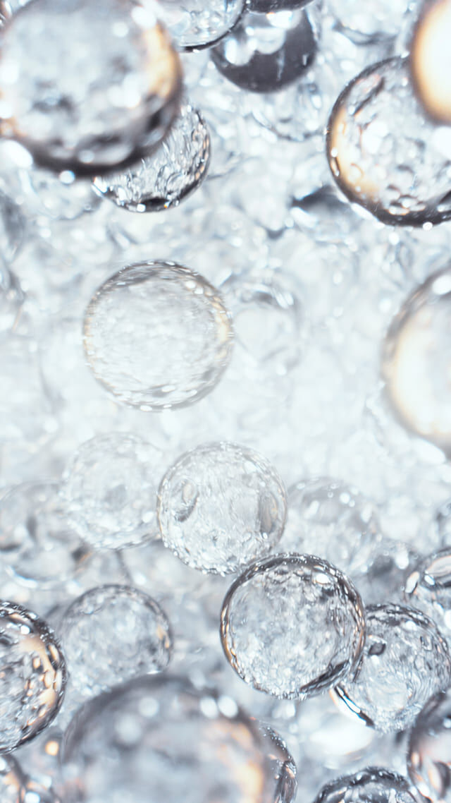 Close-up of translucent water droplets suspended in liquid.