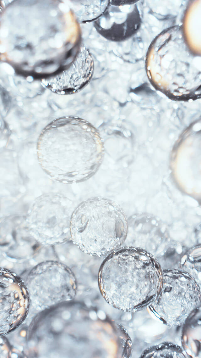 Close-up of translucent water droplets suspended in liquid.
