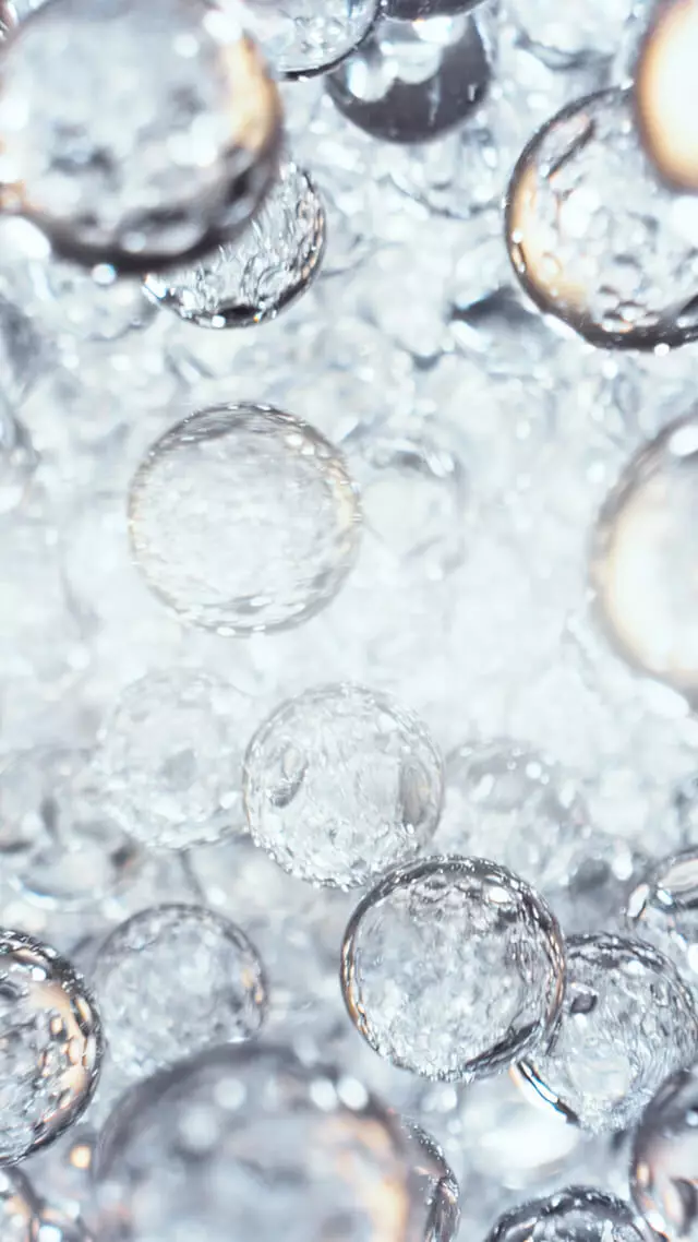 Close-up of translucent water droplets suspended in liquid.