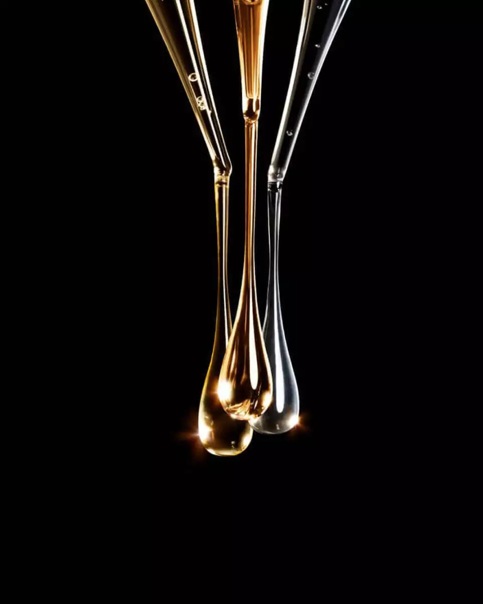 Close-up of liquid droplets falling from glass pipettes.