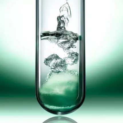 Liquid active ingredients dissolving inside a laboratory glass tube.