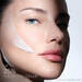 Woman's face with Helena Rubinstein REPLASTY cream and innovative bandage texture on her cheek.