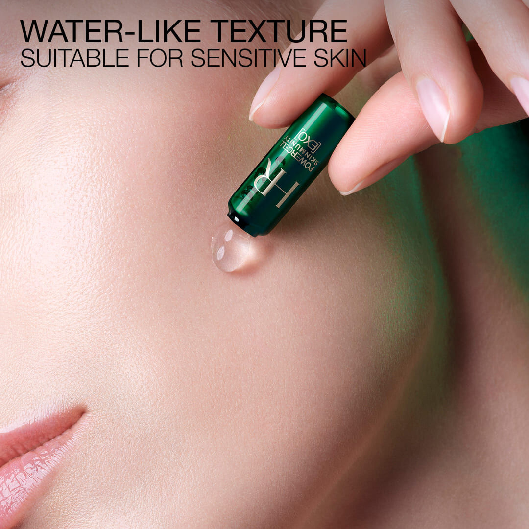 Clear water-like serum drop applied directly from the green ampoule onto skin.