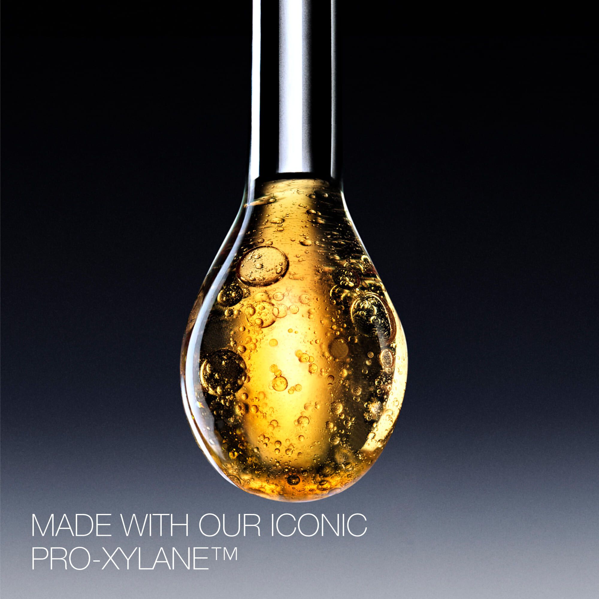 Golden serum droplet with Pro-Xylane™ ingredient, showing its rich, bubbly texture and luxurious essence.